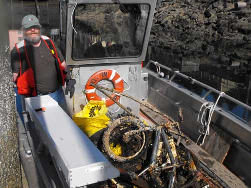 Pat Jirschele on his boat with material collected at Thomas Basin.