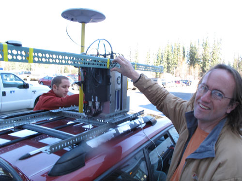 jpg Geophysical Institute graduate student Austin Johnson, left, and glacier researcher Chris Larsen install a GPS laser system on top of Larsen's Subaru Legacy