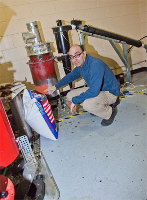 jpg UAF photo by Todd Paris Andy Soria stands shows some of the components of his research on using fish waste as fuel.