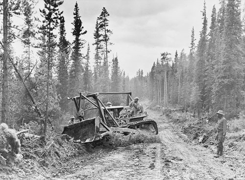 jpg Caterpillar tractor with grader widening the roadway of the Alcan Highway