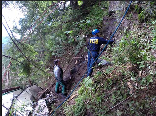 jpg NTSB investigator Clint Crookshanks and a member of the Ketchikan Volunteer Rescue Squad at the site of a sightseeing plane that crashed in Alaska on June 25, 2015.