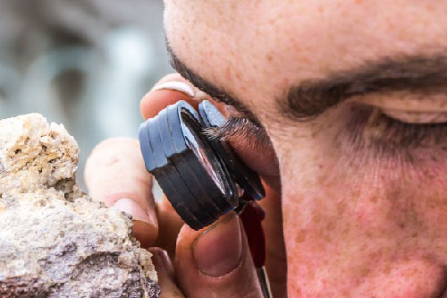 jgp Getting up close and personal with rocks: A researcher looks at the crystals that have formed in a rock found in the Wrangell Mountains.