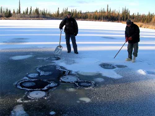 jpg University of Alaska Fairbanks student researchers Dragos Vas and Sudipta Sarkar measure methane bubbles rising from an Interior Alaska lake.