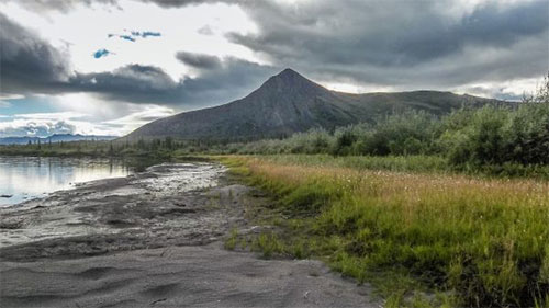 jgp A mountain rises above the Sheenjek River in July.