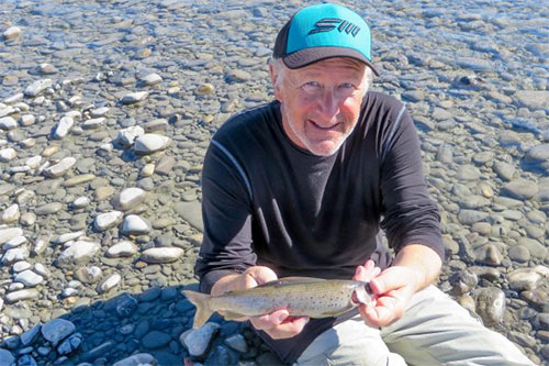 jpg Mike Fallon, a former fish culturist for the Alaska Department of Fish and Game, displays an arctic grayling caught during a float down the Sheenjek River in July.