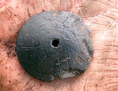 jpg Research archaeologist Scott Shirar holds one of the clay disks