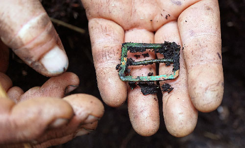 jpg Researchers discovered a brass strap buckle during the excavation.