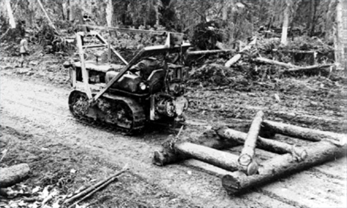 jpg Until heavier equipment arrived, the engineers had to be creative, using local supplies to continue construction. Here, a D-4 dozer pulls a makeshift grader crafted from local timber. 