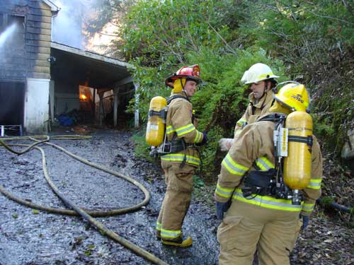 jpg Lt. Sugar, Chief Davis, Heidi Bower (with breathing apparatus) survey damage to back of house.  No entry was possible.