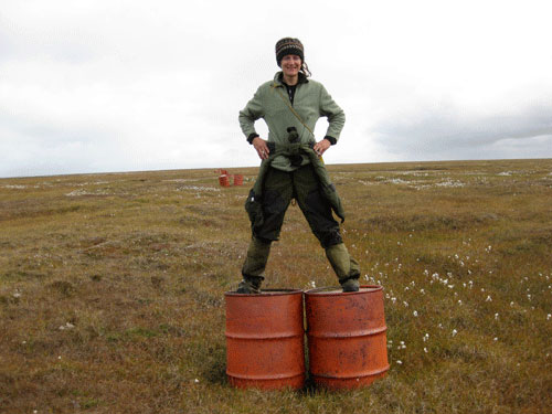 jpg Stacey Fritz standing atop two 55-gallon drums used to mark a runway at a former Dew Line site in Alaska’s Arctic.