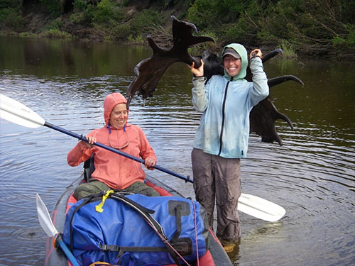 jpg Molly Yazwinski holds a 3,000-year-old moose skull with antlers still attached found in a river on Alaska’s North Slope. Her aunt, Pam Groves, steadies an inflatable canoe.