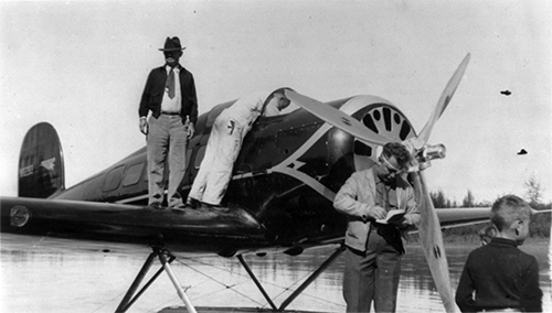 jpg Rogers standing on the wing of the seaplane, with Wiley Post standing in front of the propeller, August 1935 at Fairbanks.