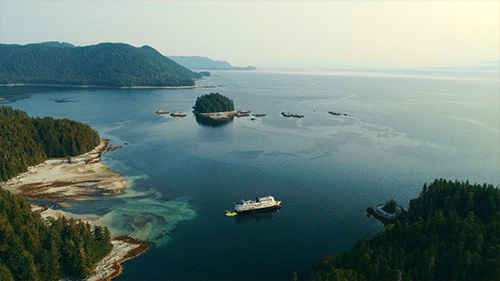 jpg An Uncruise Adventures cruise ship, with a fleet of kayaks in the water behind it, in the Tongass National Forest.