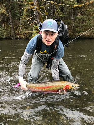 jpg Nick Whicker poses on May 10, 2018 with his first steelhead, caught on the Situk River in Yakutat with a UAS Outdoors studies class taught by professor and Salmon Fellow Kevin Maier. The fish bit onto a fly Whicker had tied that morning (it already had a hook in its tail.) 
Photo by Triston Chaney