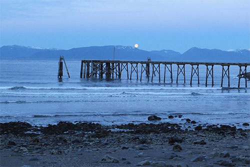 jpg The moon sets over the mountains as seen from  an Angoon beach 