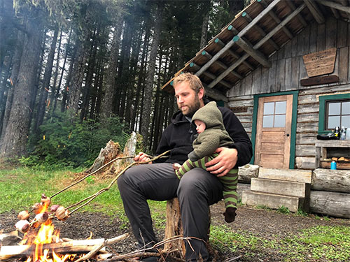 jpg Bjorn Dihle roasts bacon-wrapped venison over the fire with his seven-month-old son, Theron Dihle, on his lap, the last night of the trip.