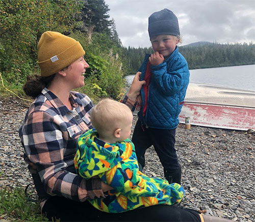 jpg Autumn Muse sits in front of Big Shaheen cabin on Hasselborg Lake with her sons Miles (on her lap) and Silas. 